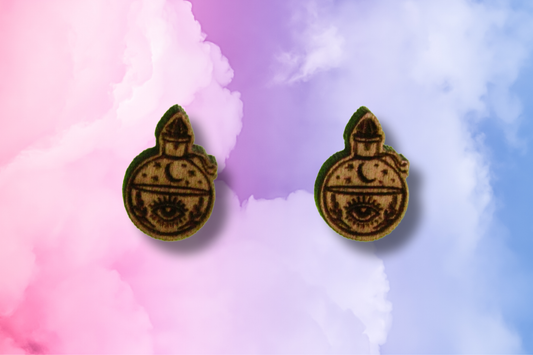 Pair of earrings with a potion bottle design on a colorful background