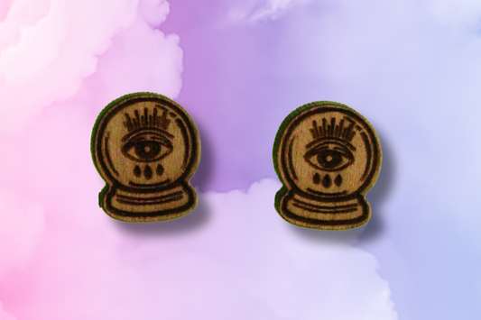 Pair of earrings with crystal ball eye design on a colorful background