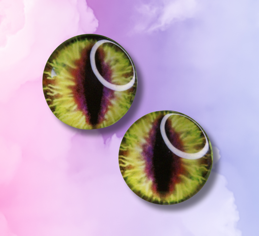Pair of round earrings with green and purple eye design on a colorful background